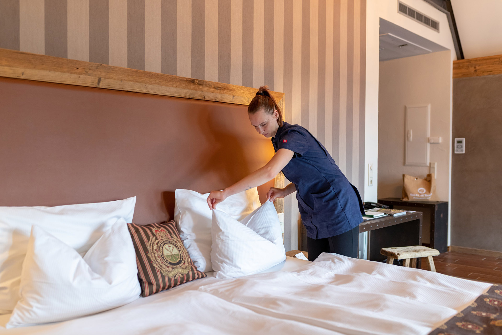 Ein Zimmermädchen bereitet das Bett für neue Gäste vor.